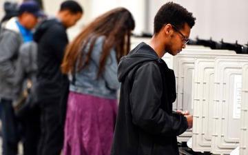 People casting ballots at a voting booth.
